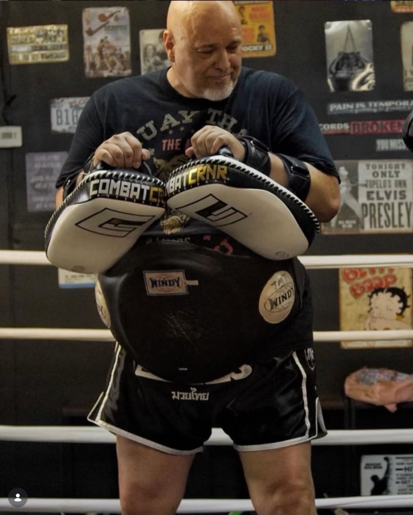Coach holding pads in the ring